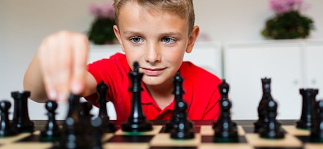 Criança jogando xadrez na aula de escola menino jogando jogo de